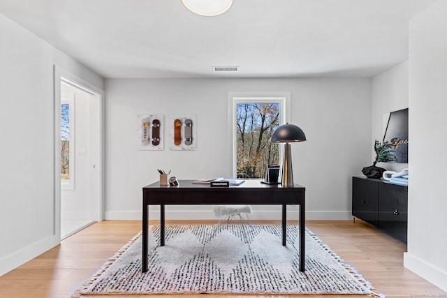 home office with light hardwood / wood-style flooring