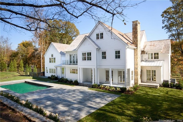 back of property with a lawn and a patio area