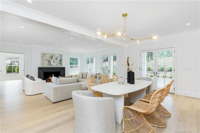 dining room with light hardwood / wood-style floors, ornamental molding, and plenty of natural light