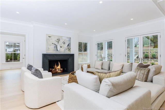 living room with crown molding, light hardwood / wood-style floors, a high end fireplace, and french doors