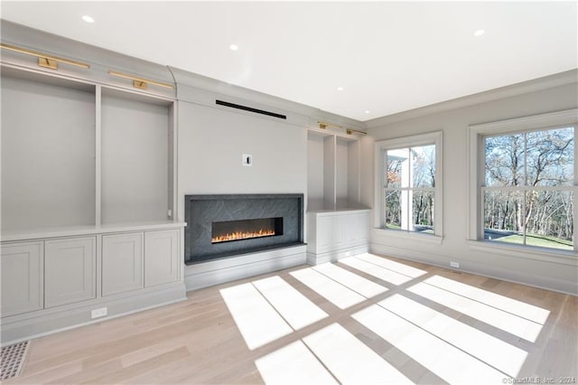 unfurnished living room featuring a premium fireplace and light hardwood / wood-style floors