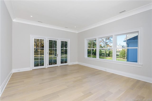 unfurnished room with light wood-type flooring and crown molding