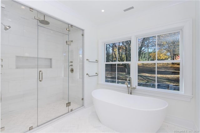 bathroom with shower with separate bathtub and plenty of natural light