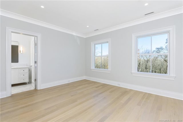 spare room featuring ornamental molding and light hardwood / wood-style flooring