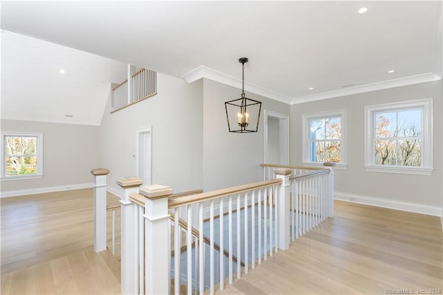 hall featuring crown molding, vaulted ceiling, light hardwood / wood-style flooring, and a chandelier