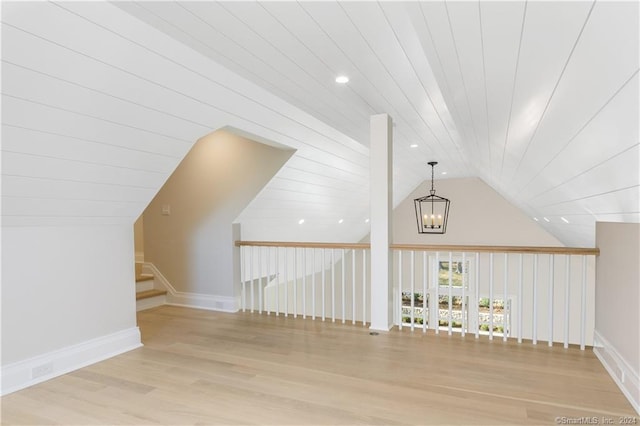 additional living space with light hardwood / wood-style flooring, a chandelier, vaulted ceiling, and wooden ceiling