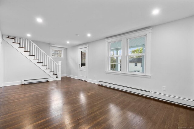 unfurnished living room with dark hardwood / wood-style flooring and a baseboard radiator