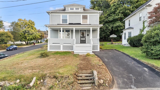 front of property featuring covered porch and a front yard