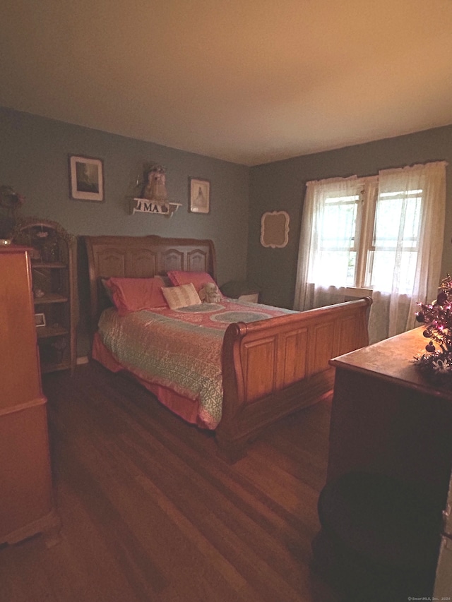 bedroom with dark hardwood / wood-style floors