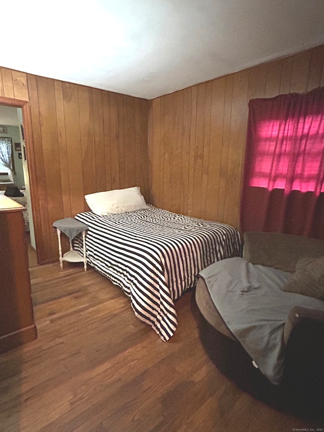 bedroom with wooden walls and dark hardwood / wood-style floors