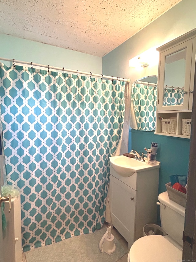 bathroom featuring vanity, a textured ceiling, and toilet