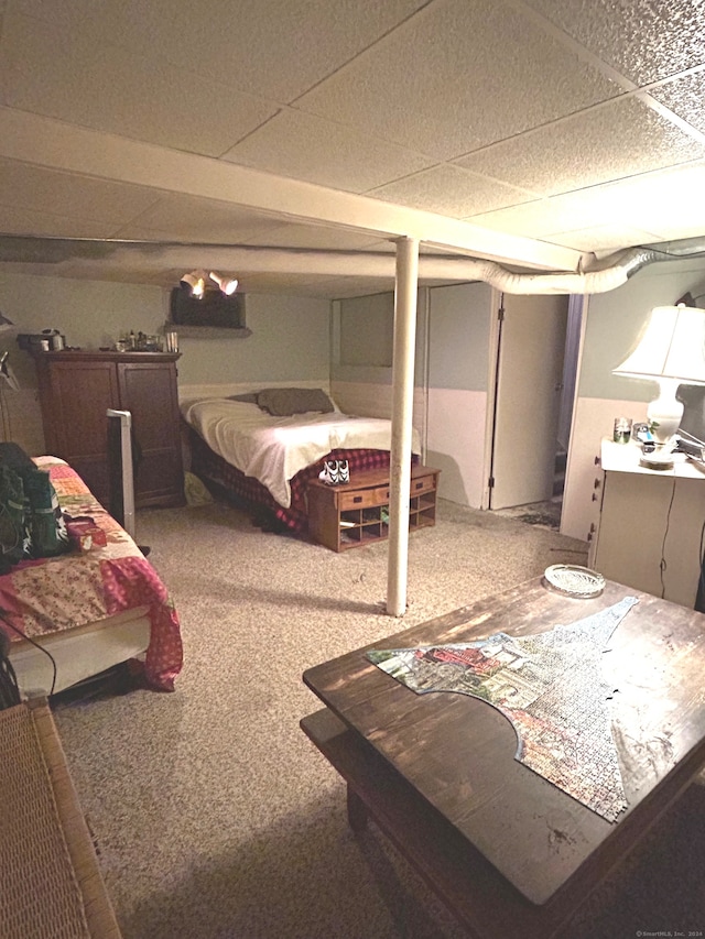 carpeted bedroom featuring a drop ceiling