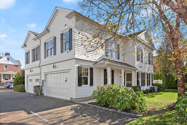 view of front of house featuring cooling unit, a garage, and a front yard