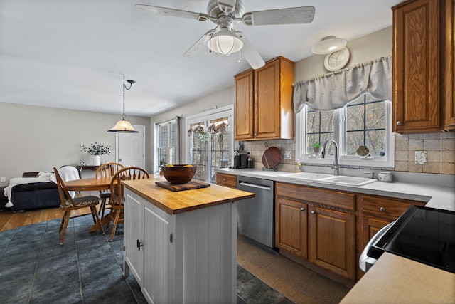 kitchen with tasteful backsplash, sink, decorative light fixtures, and stainless steel dishwasher