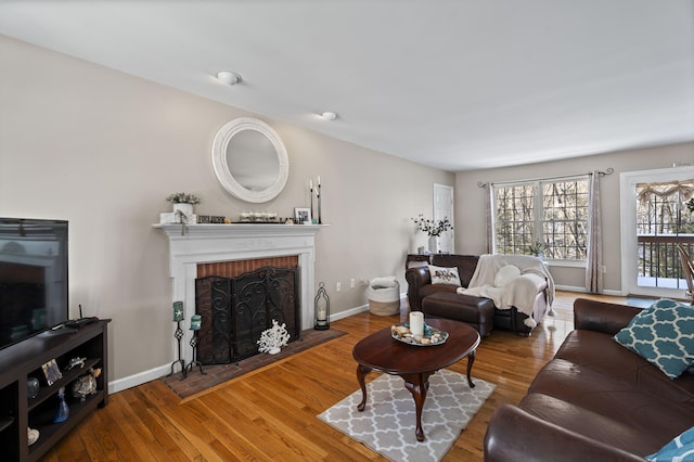 living room featuring a brick fireplace and hardwood / wood-style floors