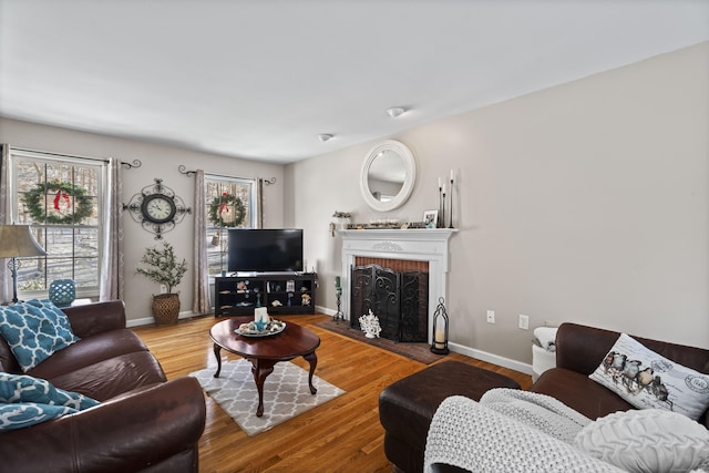 living room featuring a brick fireplace and hardwood / wood-style floors