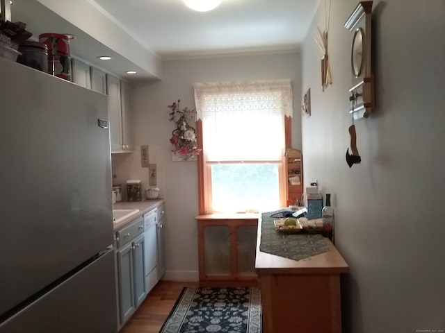 kitchen with stainless steel refrigerator, light hardwood / wood-style flooring, and dishwasher