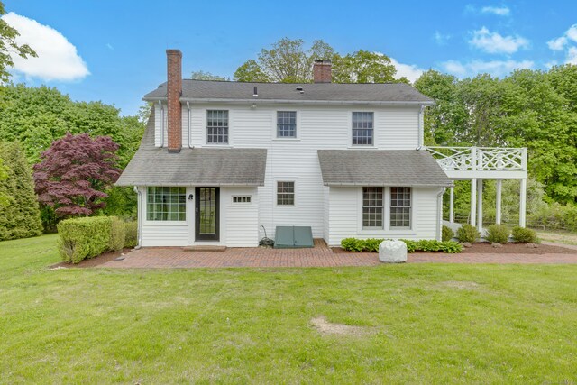 429 Chestnut Land Rd, New Milford, CT 06776 - back of house with a patio, a chimney, roof with shingles, and a lawn