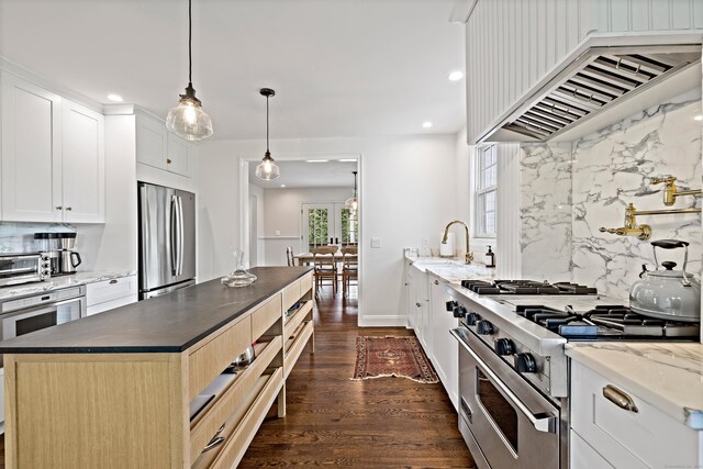 429 Chestnut Land Rd, New Milford, CT 06776 - kitchen with ventilation hood, appliances with stainless steel finishes, a toaster, decorative backsplash, and dark wood-style floors