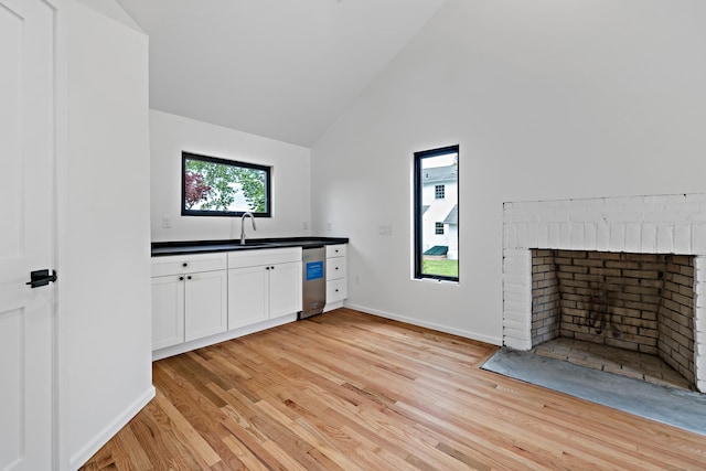 429 Chestnut Land Rd, New Milford, CT 06776 - bar with light wood-style floors, high vaulted ceiling, a fireplace, a sink, and baseboards