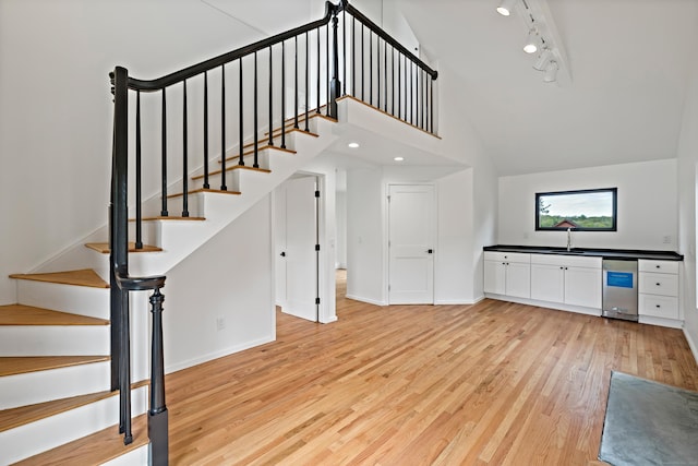 429 Chestnut Land Rd, New Milford, CT 06776 - stairs with track lighting, baseboards, a high ceiling, and wood finished floors