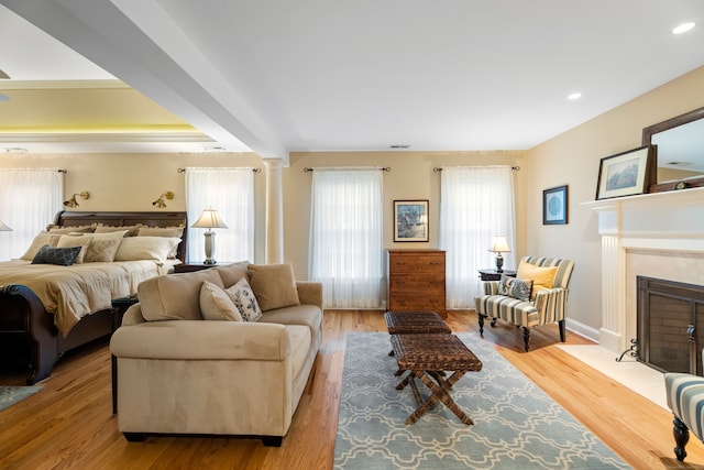 bedroom with light wood-type flooring and decorative columns