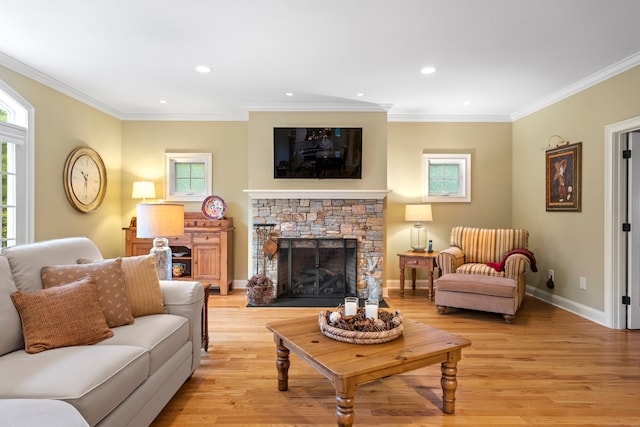 living room featuring light hardwood / wood-style flooring, ornamental molding, and a stone fireplace