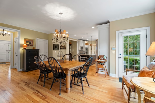 dining room featuring an inviting chandelier, light hardwood / wood-style floors, and ornamental molding