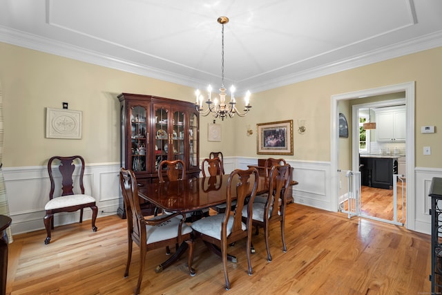 dining room featuring light hardwood / wood-style flooring, a chandelier, and ornamental molding