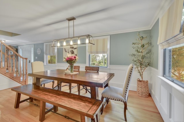 dining space featuring crown molding, light hardwood / wood-style flooring, and plenty of natural light