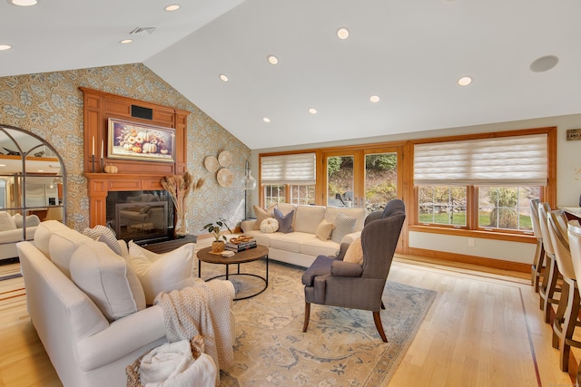 living room with light wood-type flooring and vaulted ceiling