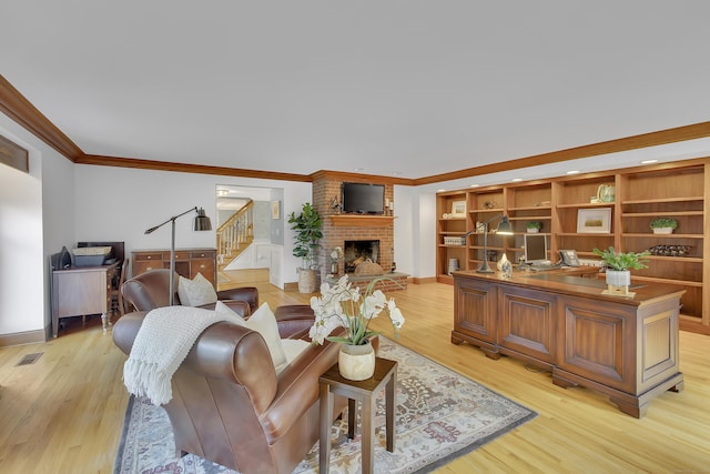 living room featuring light hardwood / wood-style floors, a brick fireplace, and crown molding