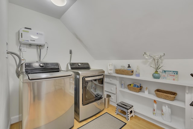 clothes washing area with light hardwood / wood-style floors and washing machine and dryer