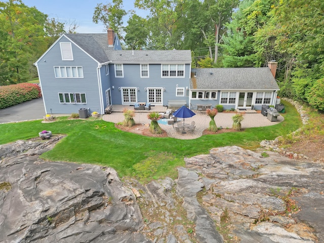 rear view of property with outdoor lounge area, a yard, a patio area, and central air condition unit