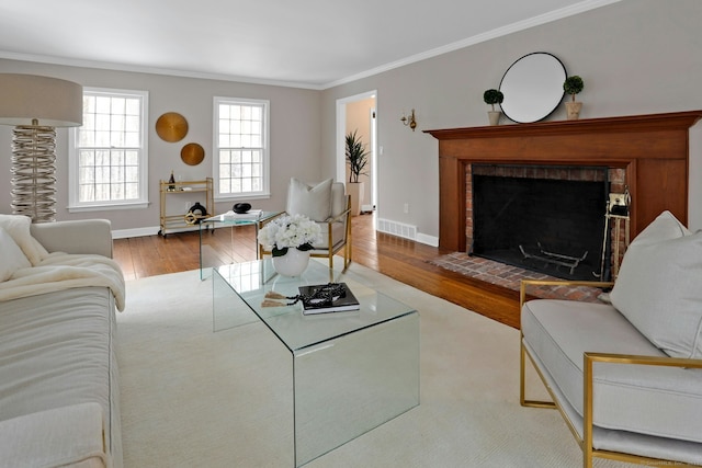 living area with visible vents, crown molding, baseboards, and wood finished floors