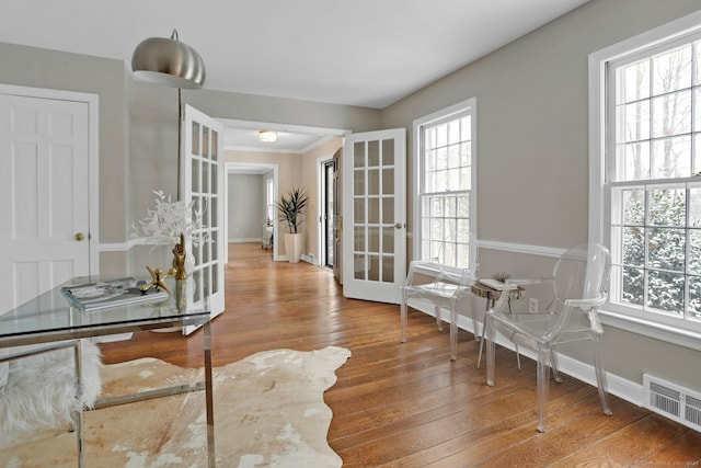 home office featuring wood-type flooring, visible vents, baseboards, and french doors