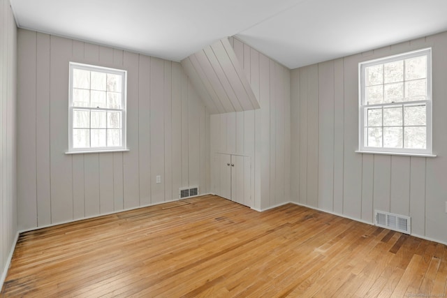 additional living space featuring plenty of natural light, light wood-type flooring, and visible vents