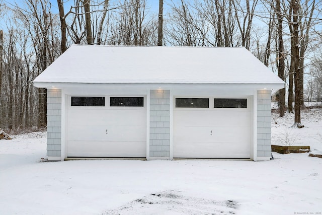 snow covered garage featuring a garage