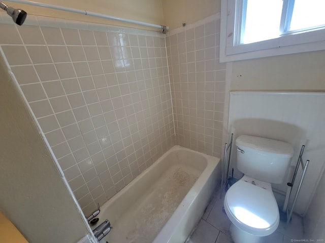 bathroom with tile patterned flooring, tub / shower combination, and toilet