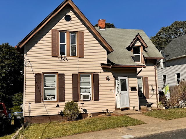 view of front of house with a front yard and cooling unit