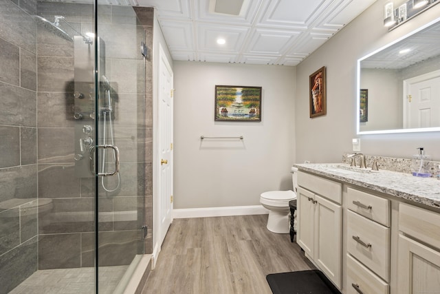 bathroom featuring an enclosed shower, toilet, vanity, and wood-type flooring