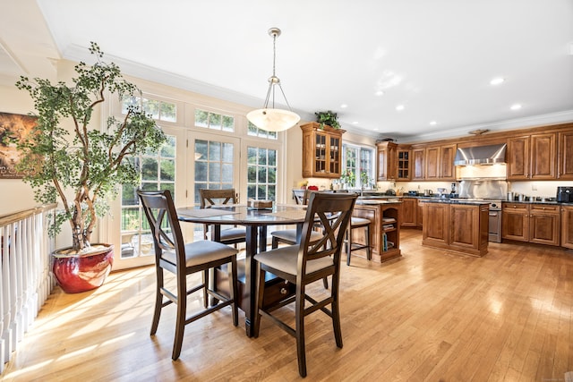 dining room featuring ornamental molding, light hardwood / wood-style flooring, and a wealth of natural light