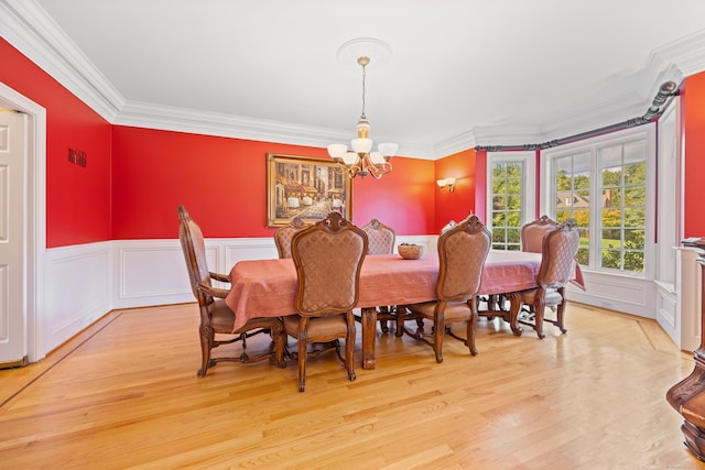 dining area with a notable chandelier, crown molding, and light hardwood / wood-style floors