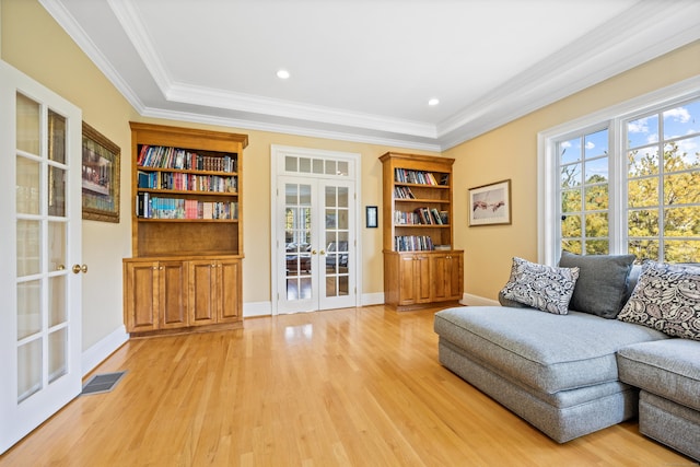 living area featuring french doors, light hardwood / wood-style flooring, and ornamental molding