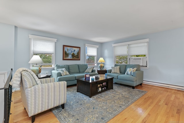 living room featuring light hardwood / wood-style flooring, a wealth of natural light, a baseboard heating unit, and cooling unit