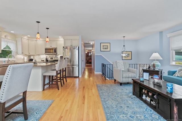 living room with light hardwood / wood-style flooring and sink