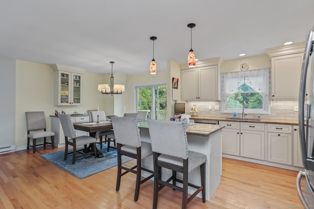 kitchen featuring decorative light fixtures, light hardwood / wood-style floors, tasteful backsplash, and a kitchen island