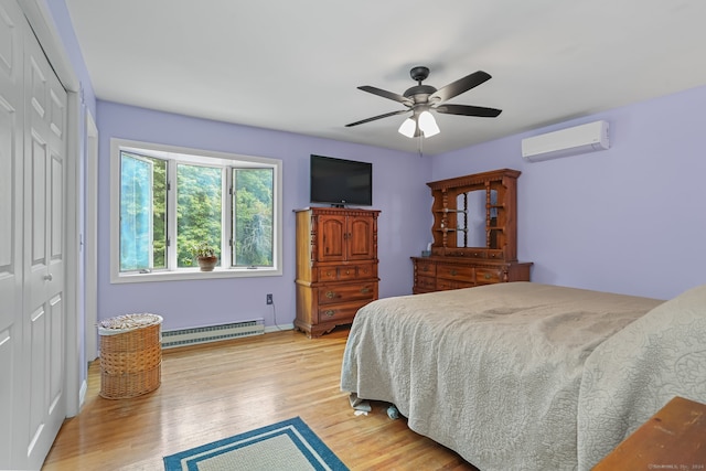 bedroom featuring light wood-type flooring, a closet, a wall unit AC, baseboard heating, and ceiling fan