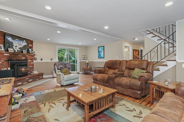 living room with ornamental molding, light hardwood / wood-style flooring, and a wood stove