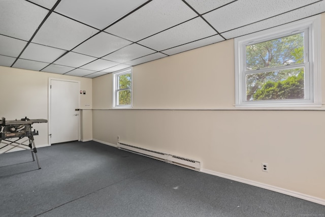 interior space featuring a drop ceiling, a baseboard heating unit, and carpet